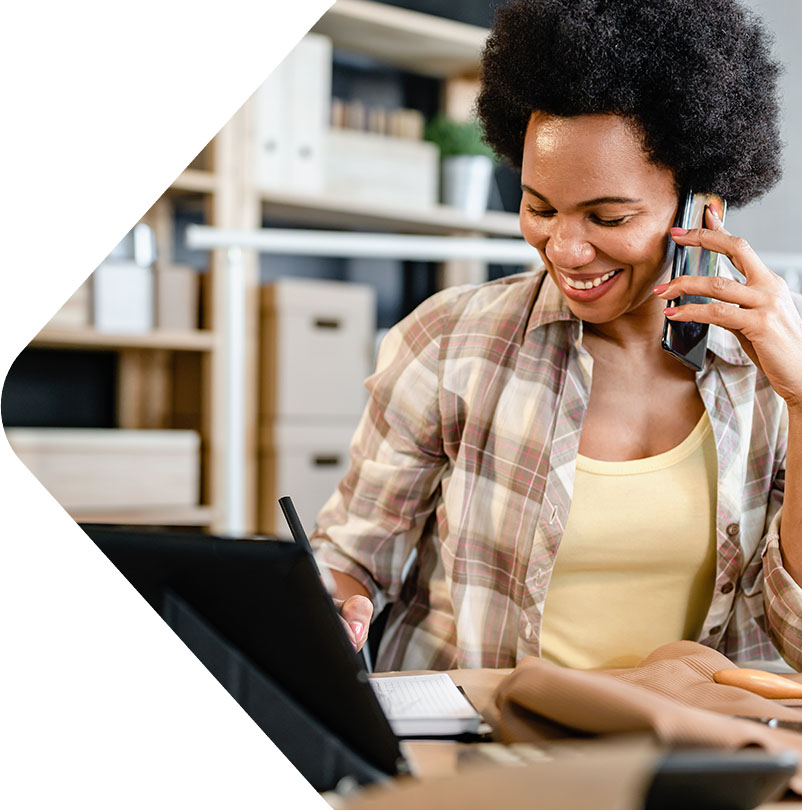 Image showing a woman on the phone in front of her laptop