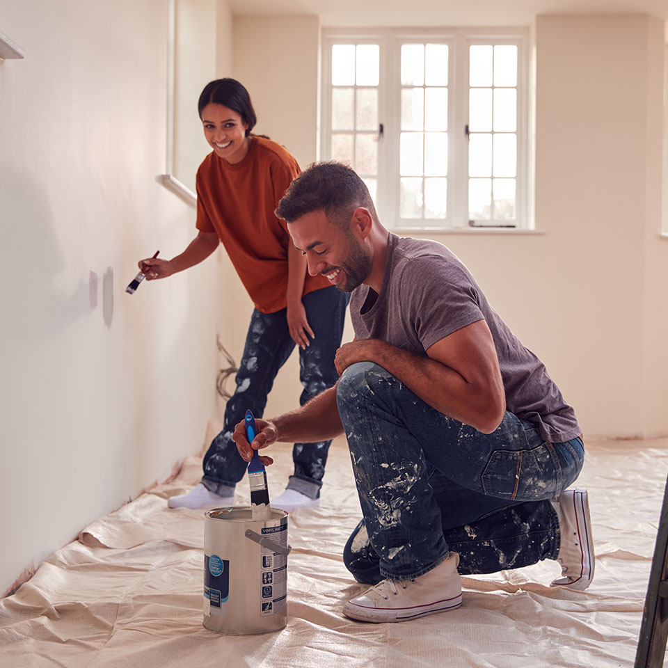 Image showing a happy couple painting samples on the wall