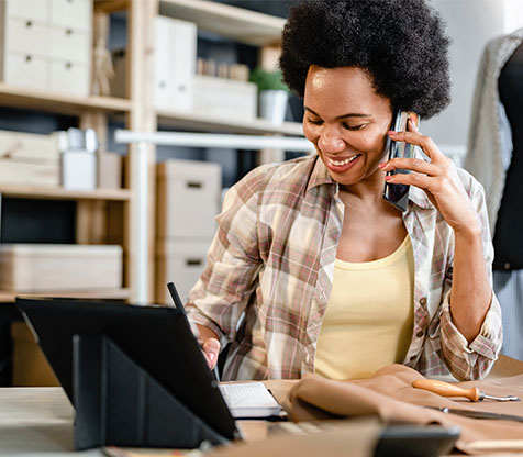 Image showing a woman on the phone in front of her laptop